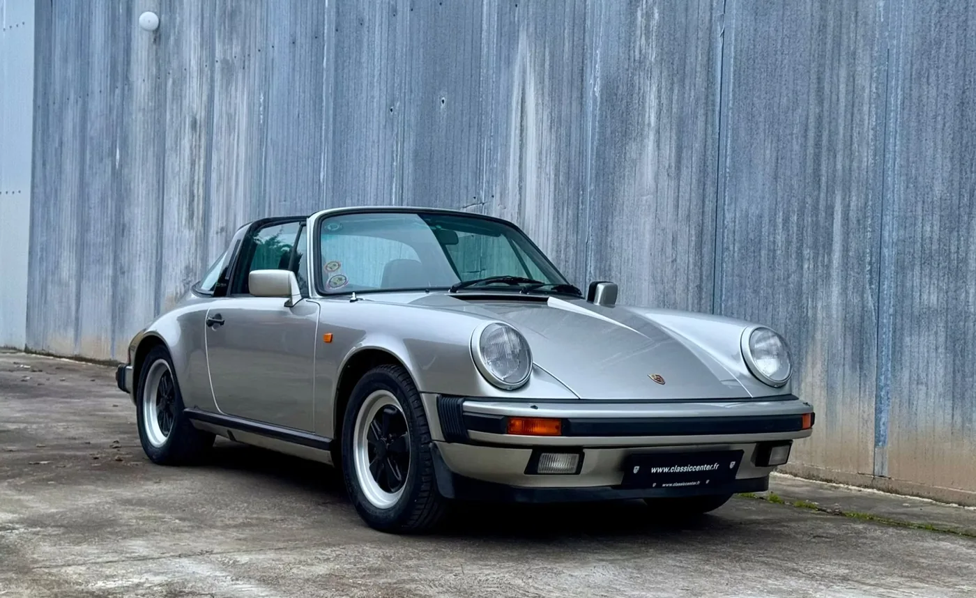 Porsche 911 Targa argentée devant un mur en métal